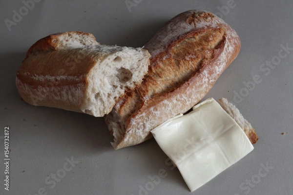 Obraz A broken baked baguette with melted cheese.