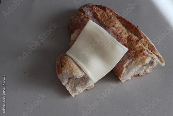 Obraz A broken baked baguette with melted cheese.