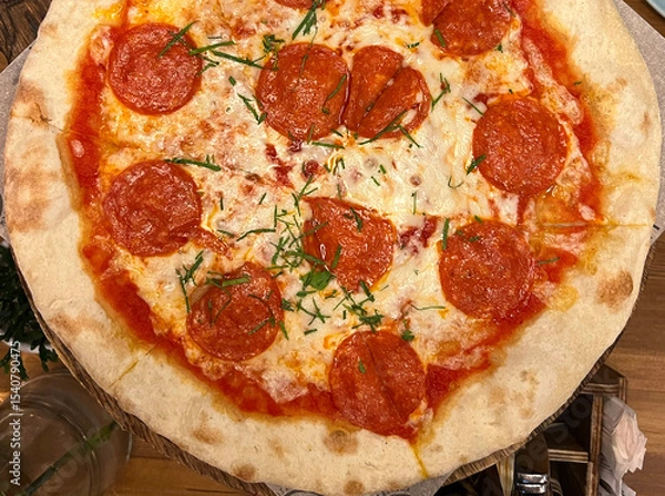 Obraz Italian pizza with whole pieces of sausage on table background.