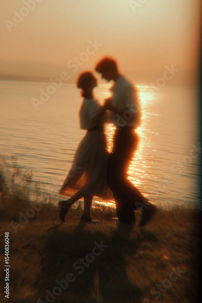 Fototapeta  Blurred Couple Dancing at Sunset by the Water
A poetic scene of a couple dancing near a calm lake at sunset, their silhouettes slightly blurred in motion, evoking nostalgic summer romance 