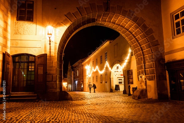 Obraz Hermosa escena de las calles de český krumlov de noche, con una par de siluetas caminado a lo lejos