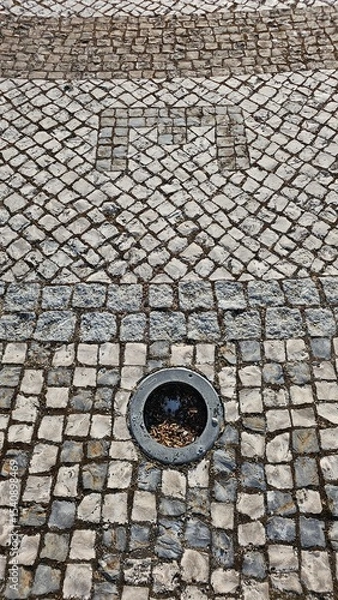 Fototapeta Letter E symbol in patterned stone pavement with circular light fixture