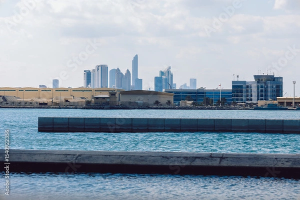 Obraz View of city with towers and skyscrapers from Saadiyat Island in Abu Dhabi, United Arab Emirates. View from water surface. High quality photo