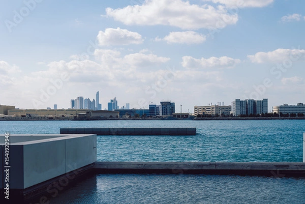 Obraz View of city with towers and skyscrapers from Saadiyat Island in Abu Dhabi, United Arab Emirates. View from water surface. High quality photo