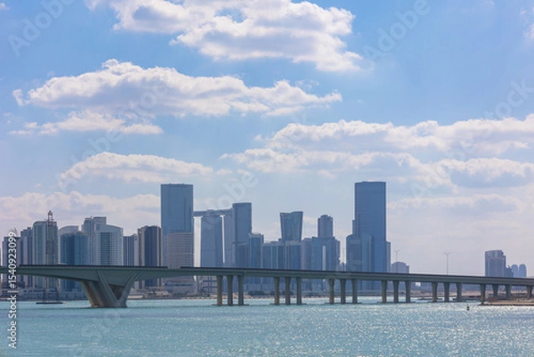 Obraz View of city with towers and skyscrapers from Saadiyat Island in Abu Dhabi, United Arab Emirates. View from water surface. High quality photo