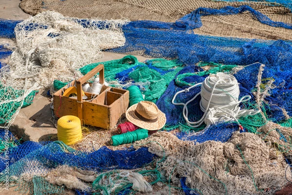 Fototapeta Fisherman's repair box with material and straw hat between fishing nets - 0260
