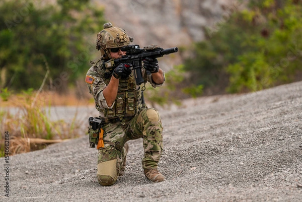 Fototapeta Special forces soldier uses a radio during a tactical operation while red flare smoke spreads across the rocky ground. Team communicates under high-alert battlefield conditions.