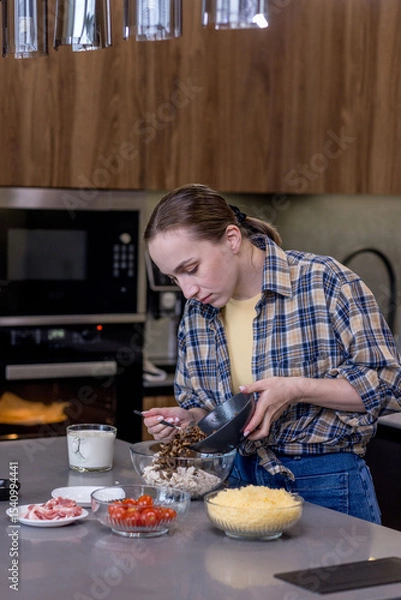 Fototapeta Woman Slicing Ingredients for Quiche in the kitchen.