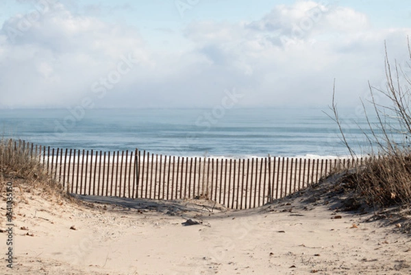 Obraz Sandy beach on blue lake in winter with snow fence and snow