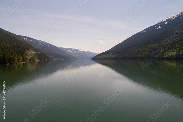 Obraz Mountains reflecting on river against sky