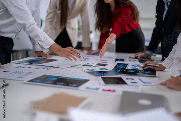 Fototapeta Business people analyzing charts and graphs, discussing financial strategy in a meeting