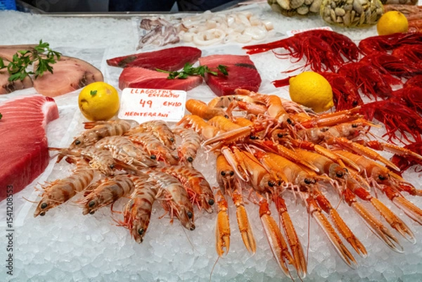 Fototapeta Different kinds of shrimps, prawns and tuna fillet for sale at a market in Barcelona, Spain