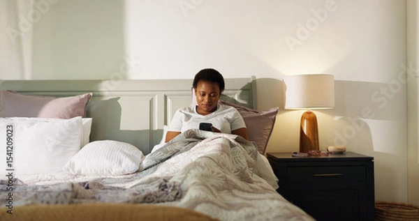 Obraz Reading, phone and wake up with black woman in bedroom for chat, notification and morning routine. Relax, social media and wellness with person in home for contact, typing and online news update
