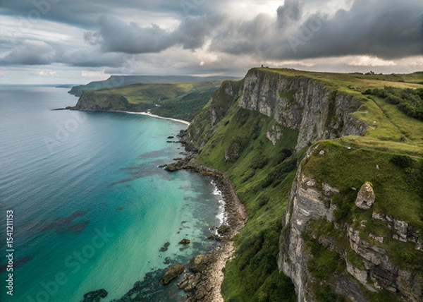 Obraz Seaside Cliffs Under Cloudy Sky: A breathtaking aerial perspective of dramatic coastal cliffs plunging into the vibrant turquoise sea. The rugged cliffs and wild sea meet.