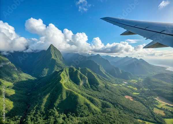 Obraz Aerial View of Island Mountains: An airplane wing provides a unique perspective on a breathtaking vista of lush, verdant mountains rising from a tropical island.