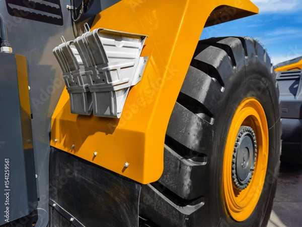 Obraz Heavy machinery tire and fender details capture in bright sunlight at construction site during daytime activity