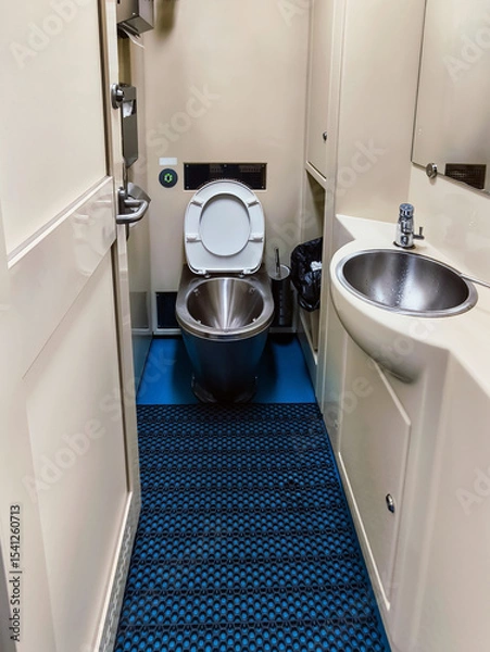 Obraz Clean restroom interior on a train featuring a toilet and sink with modern design in a compact space