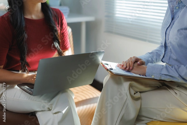 Fototapeta Businesswomen working together using laptop and documents in office