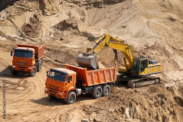 Fototapeta The process of loading sand in a sand quarry. Trucks are waiting for cargo.