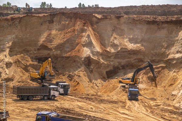Fototapeta The process of loading sand in a sand quarry. Trucks are waiting for cargo.