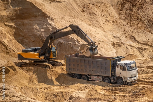 Fototapeta The process of loading sand in a sand quarry. Trucks are waiting for cargo.
