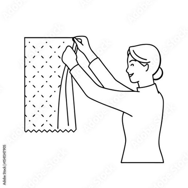 Fototapeta Woman hanging a fabric with a stitched pattern on a wall with cheerful expression.