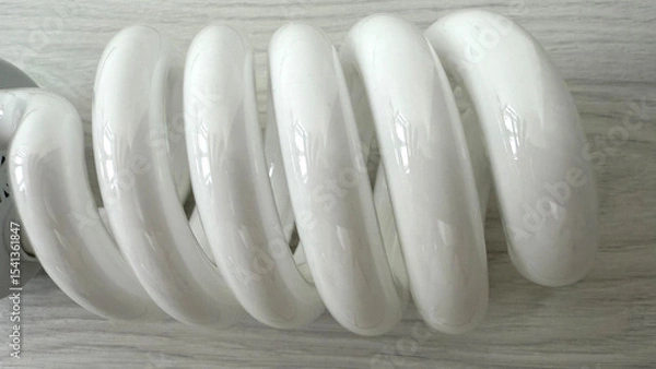 Obraz Close up of large spiral compact fluorescent light bulbs (CFL). Energy-saving daylight lamps with E27 screw base on light wooden background, top view