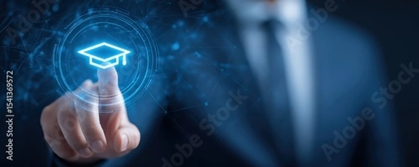 Obraz A person in a suit interacts with a digital interface featuring a glowing graduation cap icon symbolizing online education or e-learning.