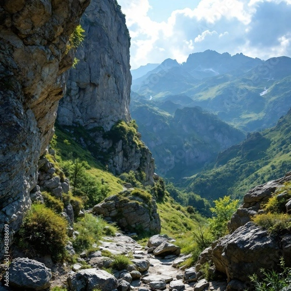 Obraz Rocky trail through green mountains with dramatic cliffs and distant peaks

