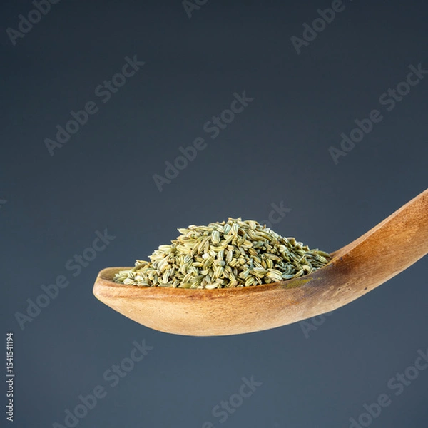 Obraz Heap of fennel spice seeds on rustic wooden utensil, great for healthy cooking and ingredient themes