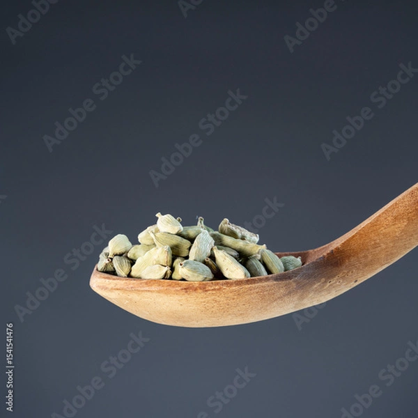 Obraz Whole cardamom seeds in natural wood spoon, ideal for aromatic seasoning and exotic recipe preparation concepts