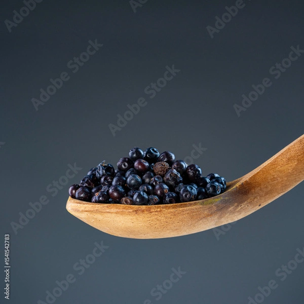 Obraz Fresh dried juniper berries in natural wood ladle, ideal for culinary herbs and aromatic cooking ingredient concepts