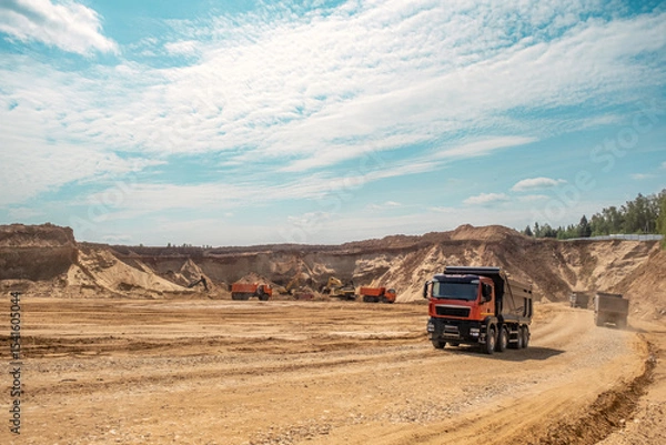 Fototapeta A loaded car drives out of a sand quarry. Sunny weather and clear skies