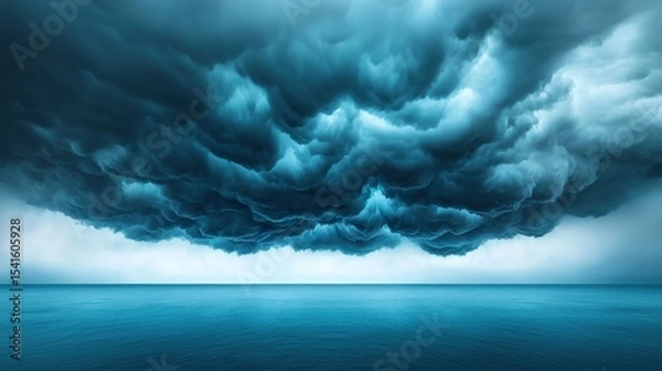 Fototapeta Black storm clouds gathering over a vast ocean, creating a powerful and dramatic scene.