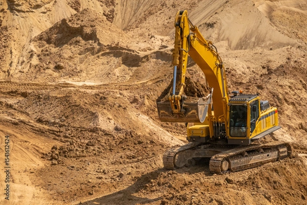 Fototapeta A caterpillar tractor works with a bucket in a sand pit. Sand mining