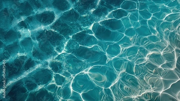 Fototapeta A mesmerizing, top-down view of turquoise water, with sunlight creating intricate, shimmering patterns on its clear surface