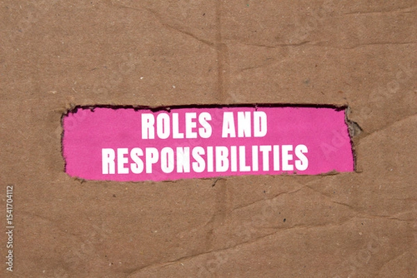 Obraz Roles and responsibilities message written on ripped torn cardboard paper on pink background. Conceptual roles and responsibilities symbol. Copy space.