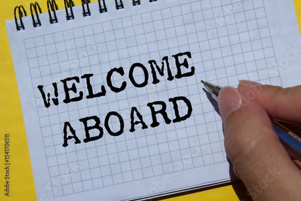 Obraz Welcome aboard message written on notebook page on yellow background. Conceptual welcome aboard symbol. Copy space.