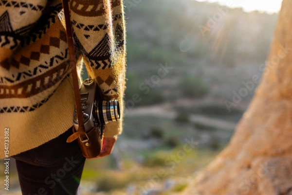Fototapeta happy woman in the mountains with a camera in her hands enjoying the moment. trekking and hiking. girl with a camera.