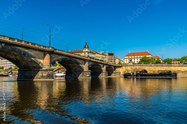Fototapeta A view from the Vltava river passing under the Palacke bridge in Prague in springtime