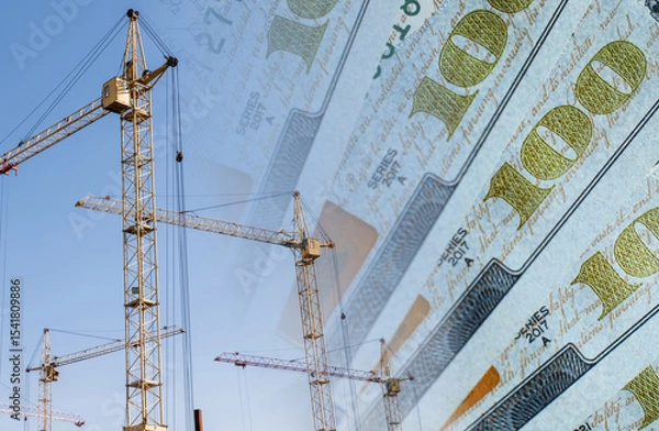 Fototapeta Construction cranes on a background of money. Сoncept of rising and changing construction costs