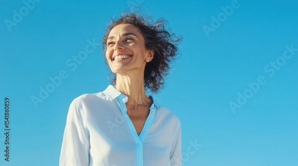 Fototapeta Joyful Woman Smiling Under a Sunny Sky: Embracing Freedom and Happiness. A vibrant portrait capturing a moment of pure bliss and carefree joy.