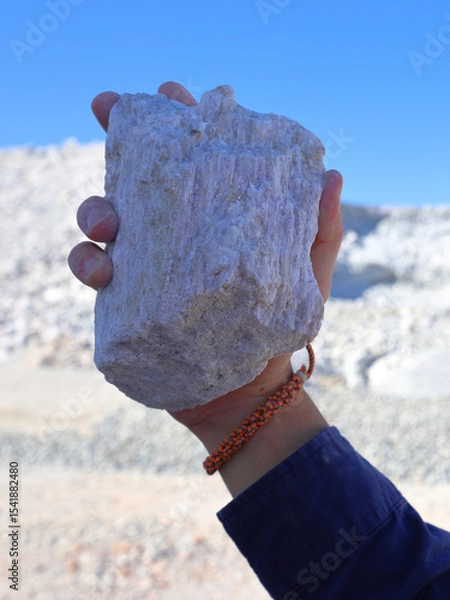 Fototapeta Spodumene ore, lithium bearing mineral, held in hand. Mine, mining of critical minerals, raw materials, for energy transition and storage