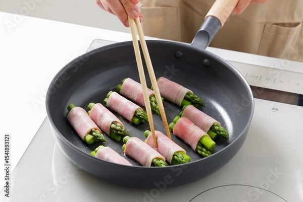 Fototapeta フライパンでアスパラベーコンを焼く料理のシーン　Asparagus Bacon Being Cooked in a Frying Pan