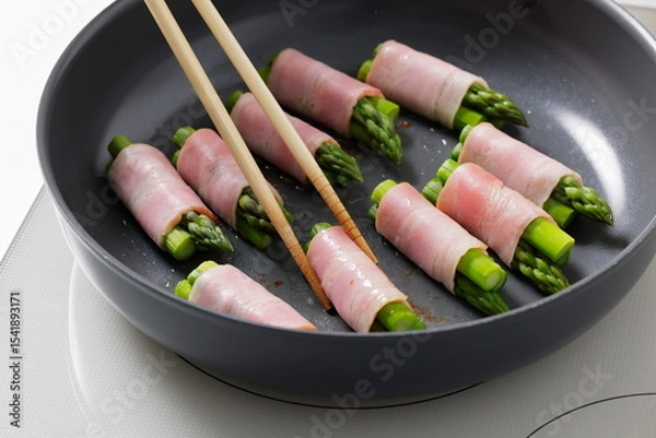 Fototapeta フライパンでアスパラベーコンを焼く料理のシーン　Asparagus Bacon Being Cooked in a Frying Pan