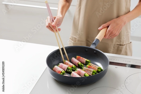 Fototapeta フライパンでアスパラベーコンを焼く料理のシーン　Asparagus Bacon Being Cooked in a Frying Pan