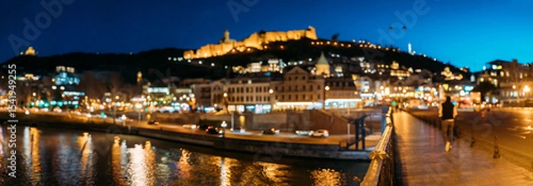 Fototapeta Tbilisi, Georgia. Panoramic Scenic View Of Impregnable Fortress Narikala Fortress, Metekhi Church. Night Boke Bokeh Blurred Ancient Fortress Narikala In Old Town Of Tbilisi. Caucasus. Abstract Blurred