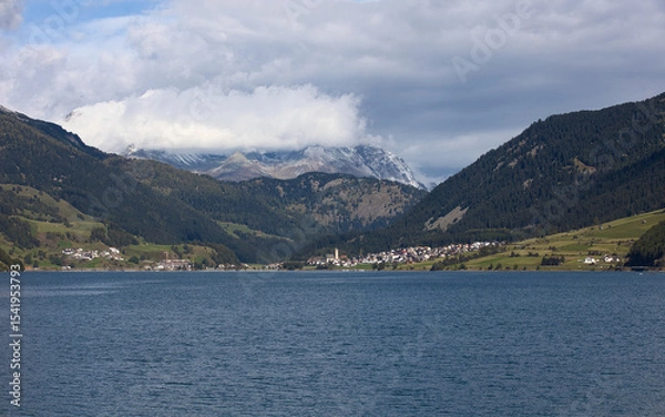Fototapeta The village of Reschen on Lake Reschen is set in an impressive mountain landscape.