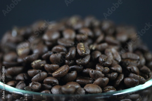 Fototapeta Roasted Coffee Beans: A close-up view of a rich, aromatic pile of roasted coffee beans, perfect for your morning brew, showing their inviting dark texture.