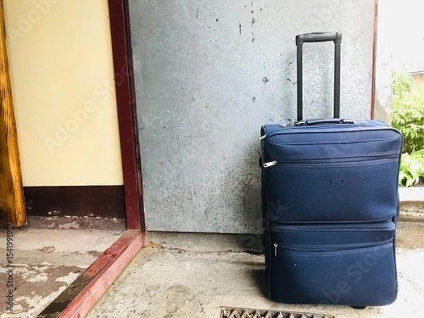 Obraz Travel suitcase placed at the entrance of a building